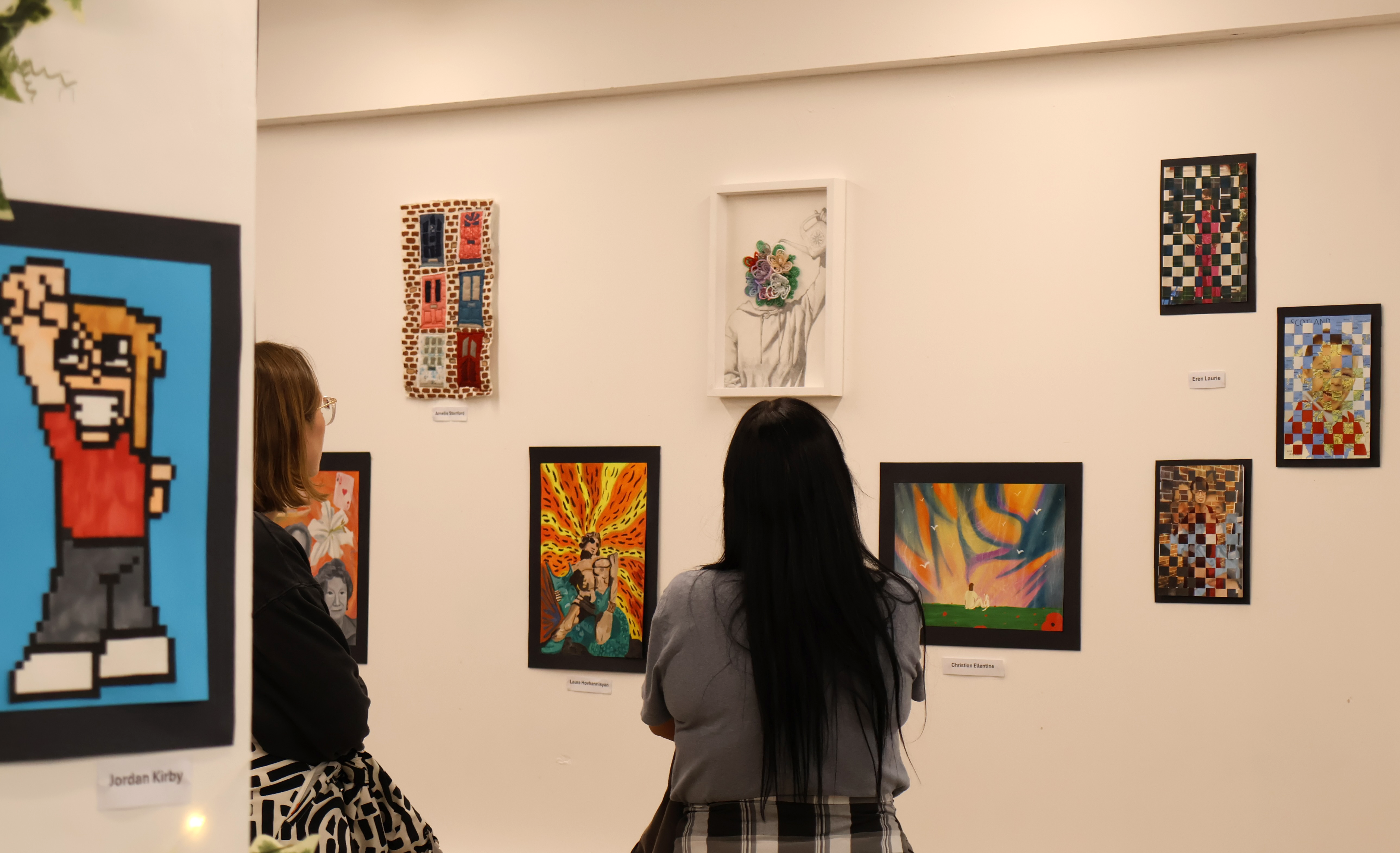 Members of the public viewing the Playland exhibition by COPC art and design students