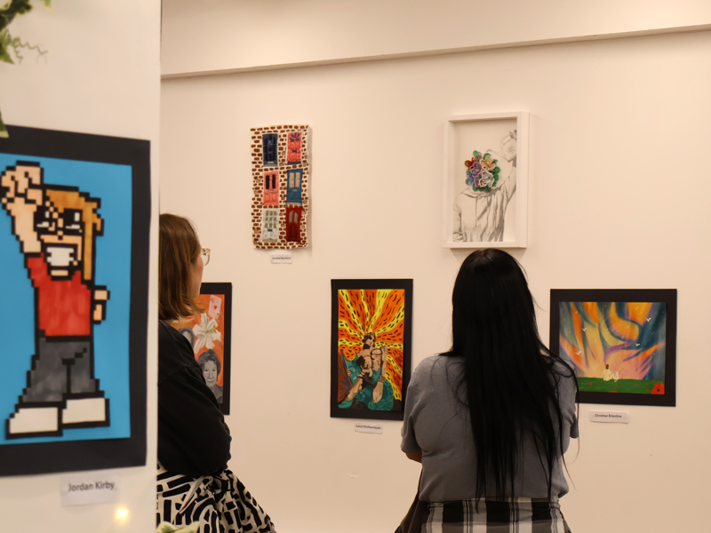 Members of the public viewing the Playland exhibition by COPC art and design students