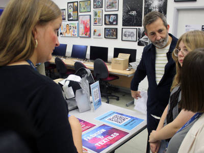 A staff member talks to a family about fashion and textiles courses