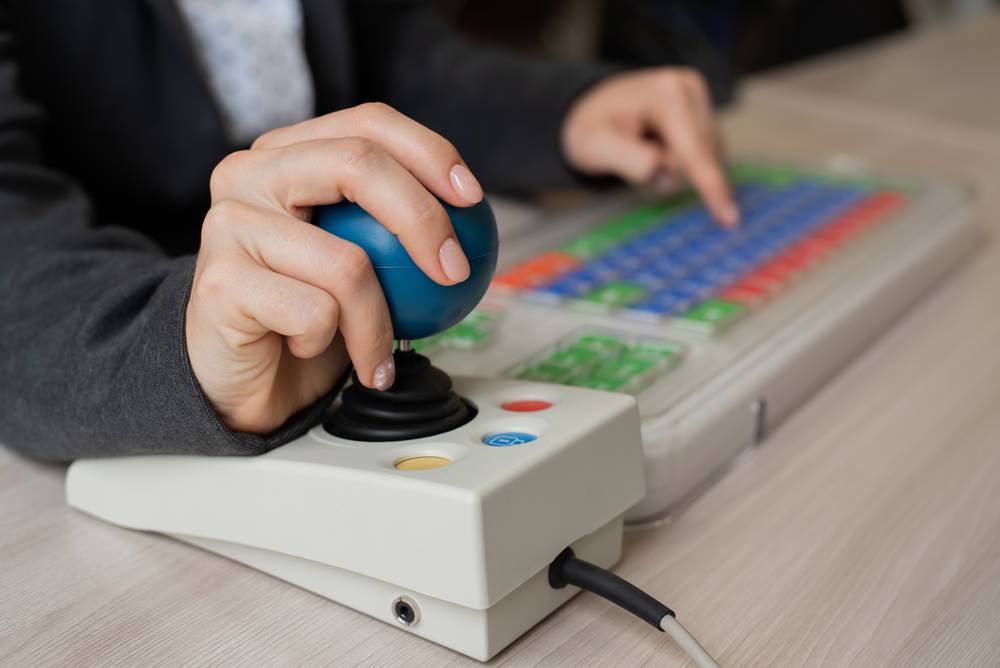 Womans hand holding a specialised computer mouse.