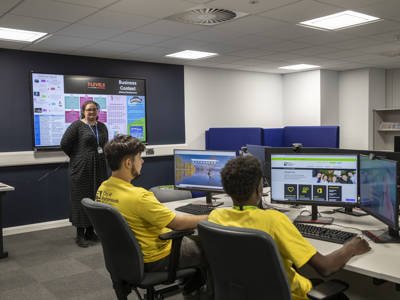 Two students using computers in a business classroom at City of Portsmouth College 