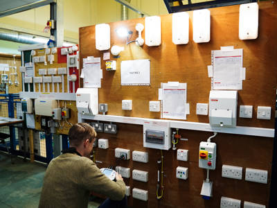 An electrical test rig and a student working at City of Portsmouth College 