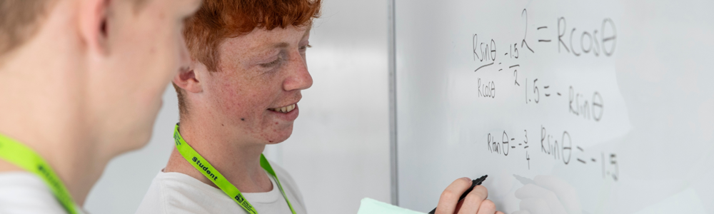 A student writing maths on a whiteboard