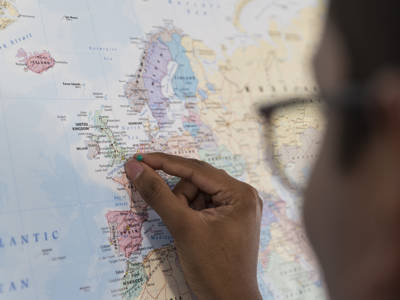 Someone placing a pin on a world map 