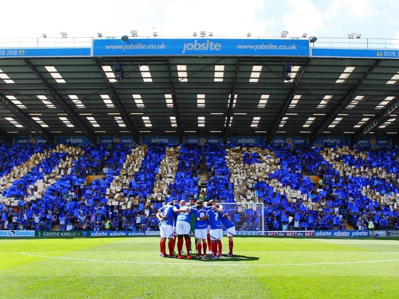 Portsmouth Football players in a group huddle at Fratton Park.