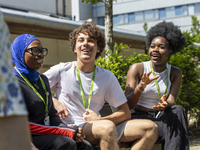 Three City of Portsmouth College students talking in a social outdoor space at Highbury Campus