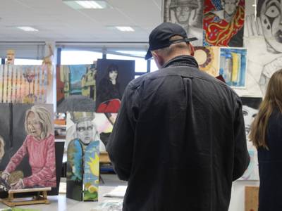 A visitor looks at artwork by students