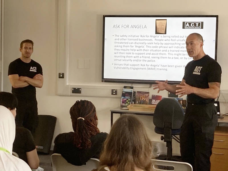 Representatives of ACT Self Defence talk through their presentation with students, watching on