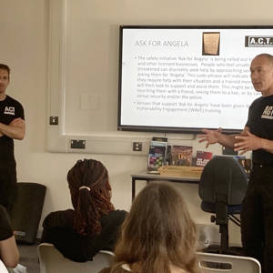 Representatives of ACT Self Defence talk through their presentation with students, watching on