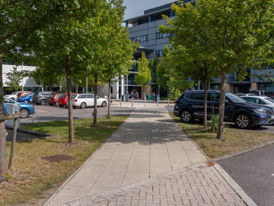 Highbury Campus entrance and car park viewed from a tree-lined walkway
