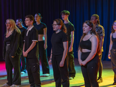 Performing arts students standing on stage doing a performance 