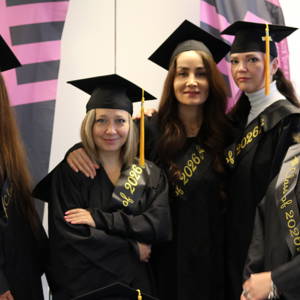 a group of five ESOL level 2 students in their graduation gowns