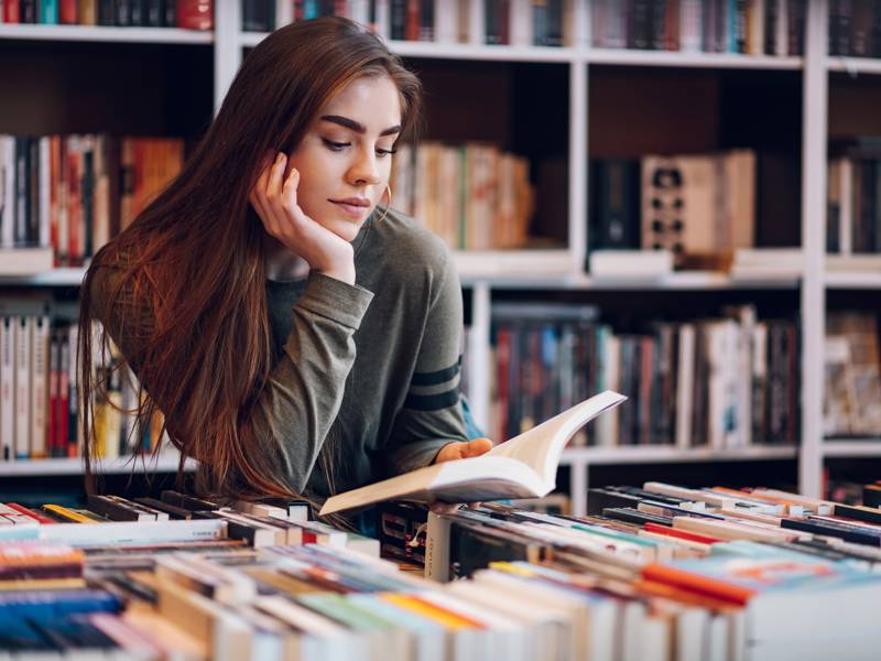 Female student reading book in the library
