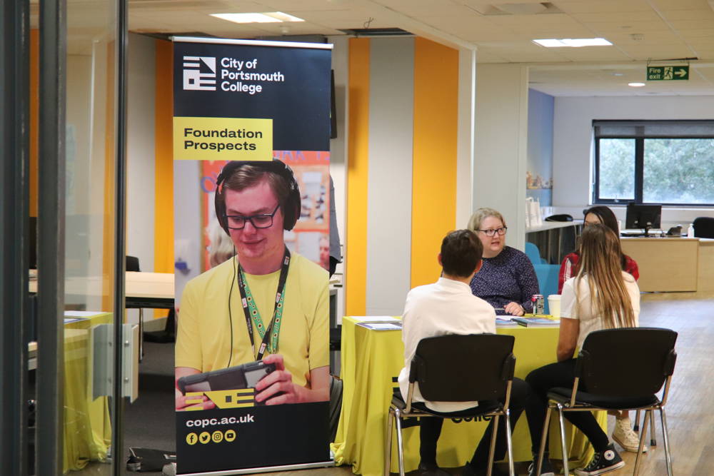 Prospective Students sat at Foundation Prospects desk talking to staff at Open Event.