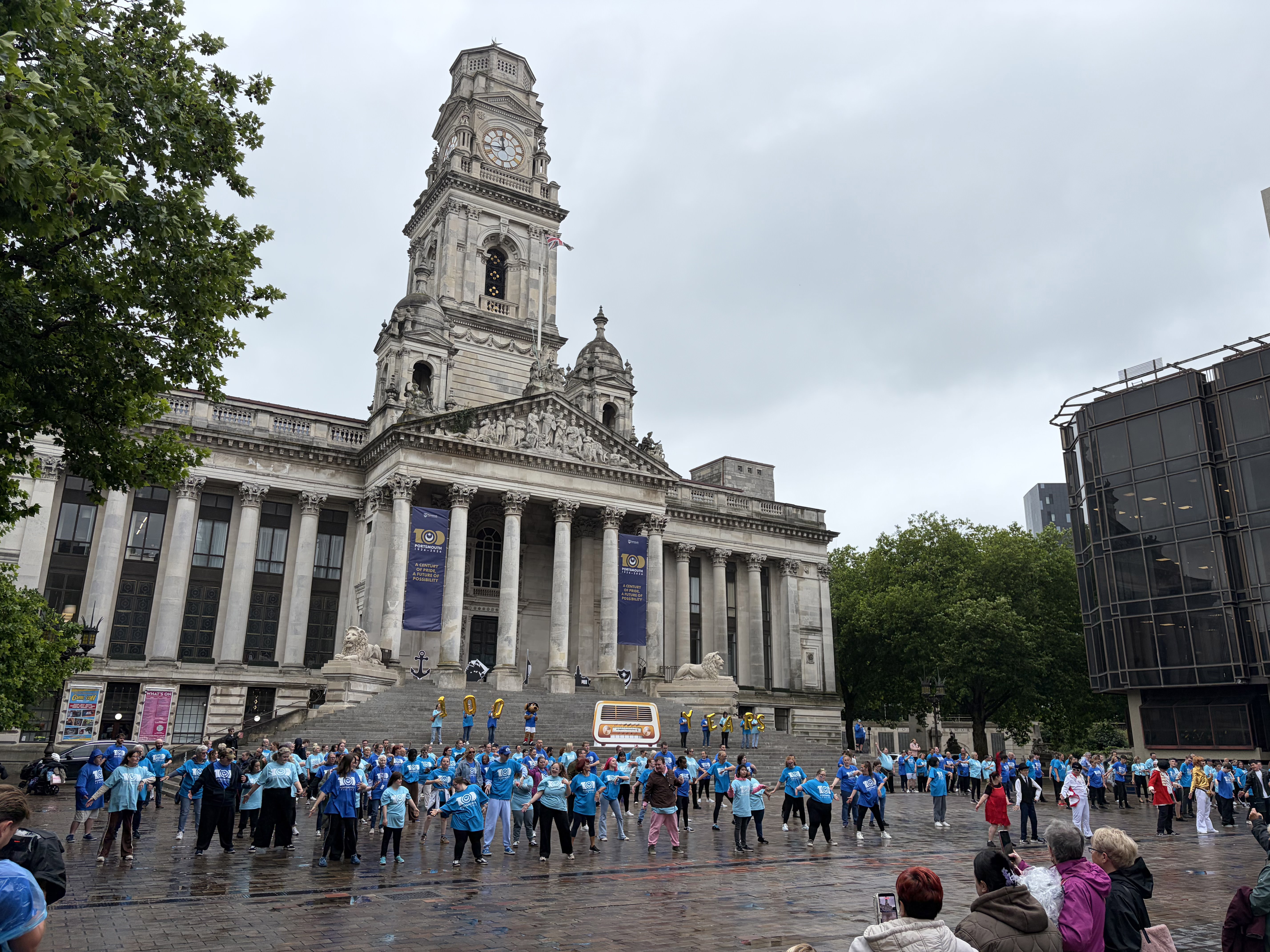 A panoramic shot of Portsmouth's Guildhall Square. In front are 250 performers in the finale of their Portsmouth 100 flashmob dance.