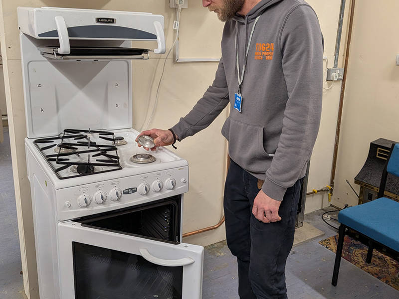 A gas trainee piecing together a gas hob.