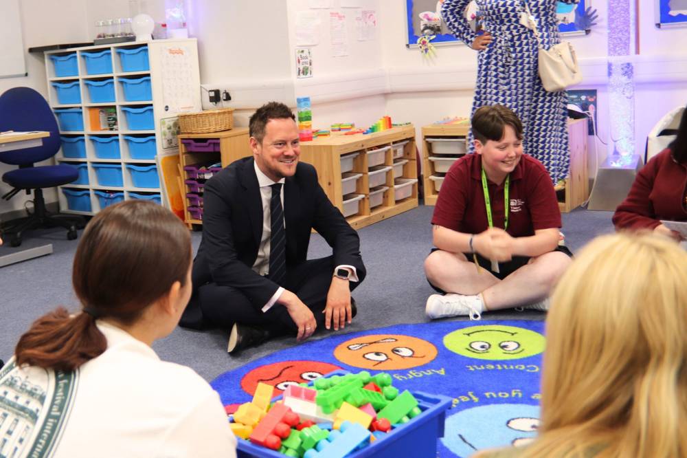 Stephen Morgan MP sitting with T Level students at the HoneyPot Nursery