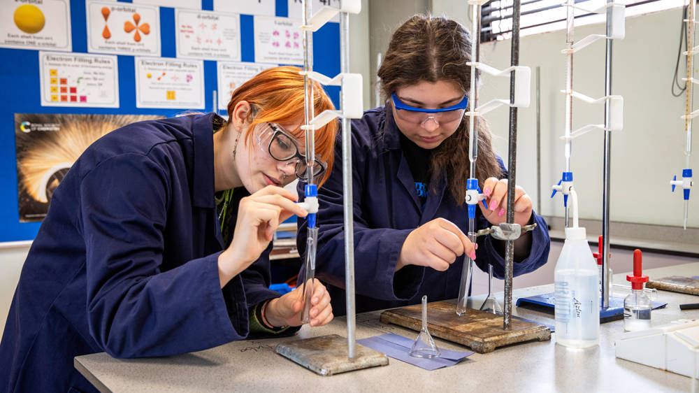 Chemistry students in laboratory working on experiment.