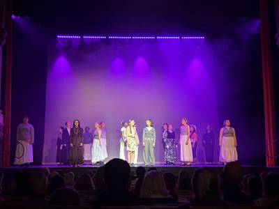 The cast sing a song, with lead character Maya (June Creamer) and Gloria Steinem (Maya Bull) centre stage
