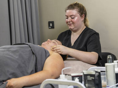 Beauty therapy student providing a facial treatment to a client