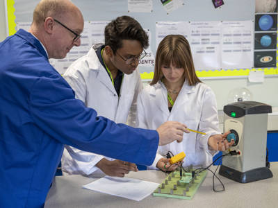 Students and a lecturer using scientific physics equipment 