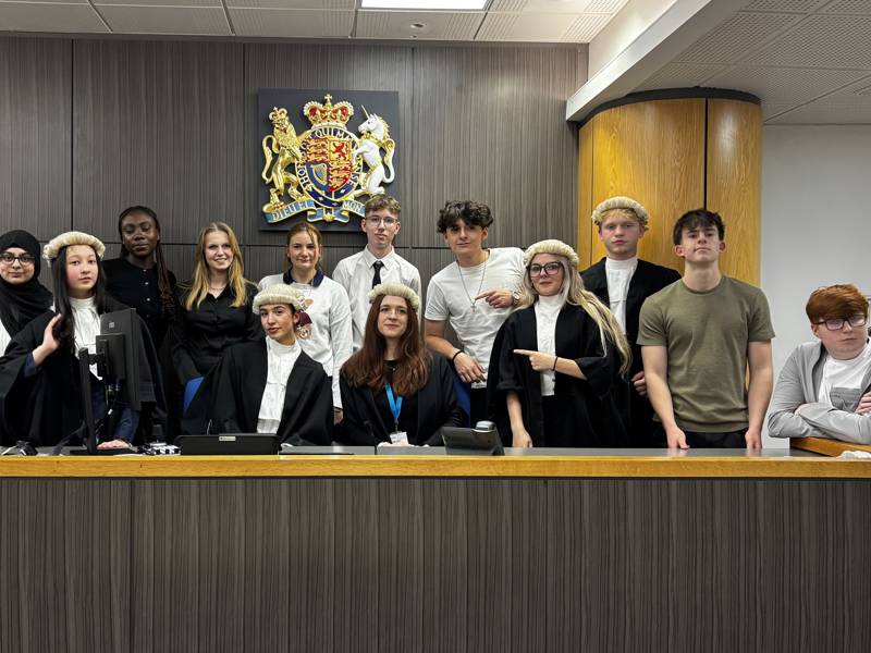 COPC students stand at the bench at a Portsmouth court following a mock trial experience
