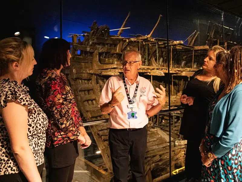 A staff member leading a guided tour at The Mary Rose Museum 