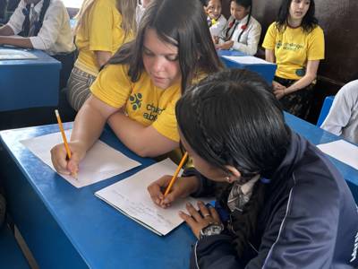 A City of Portsmouth College student teaching a young student in Nepal 