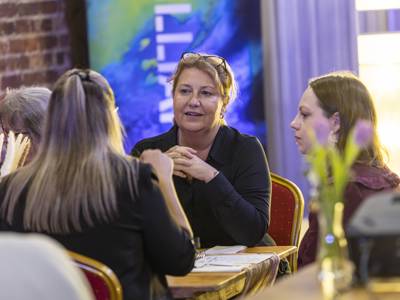 Principal and CEO Katy Quinn chats with guests on their table at the COPC x Unloc dinner