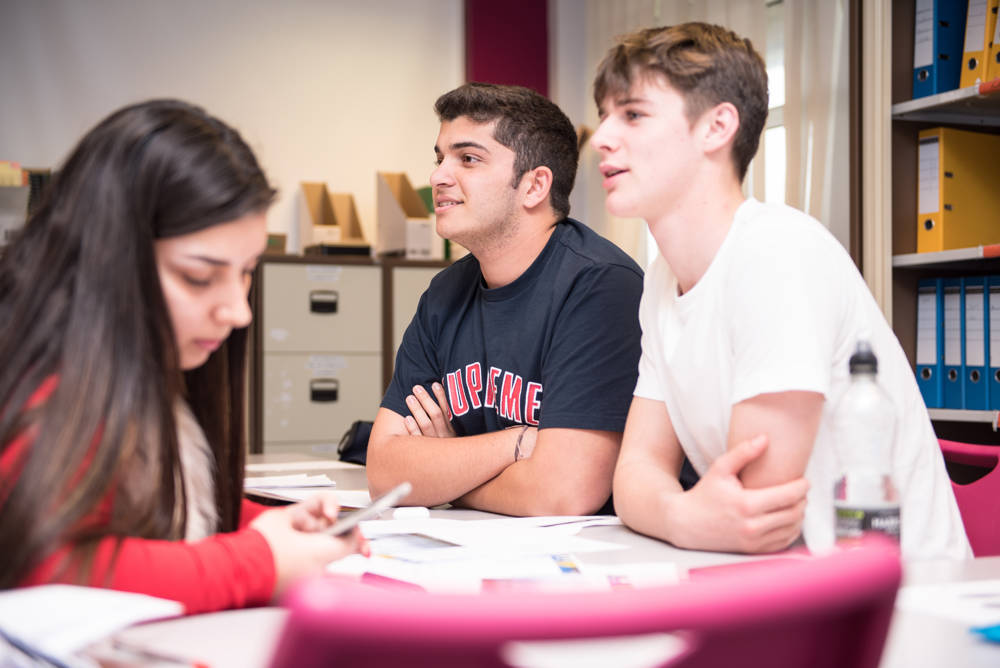 3 Global students from City of Portsmouth College studying at a desk 