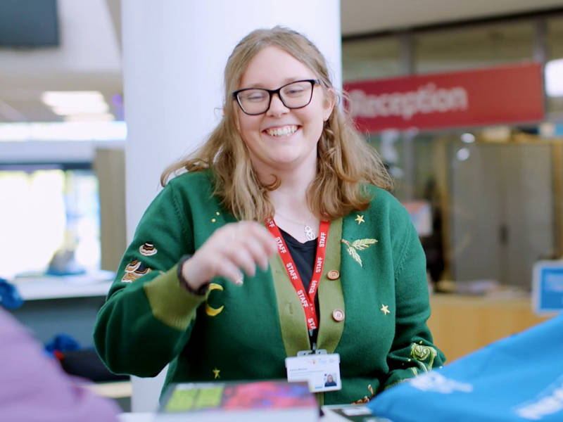 COPC staff smiling at welcome desk during an open event