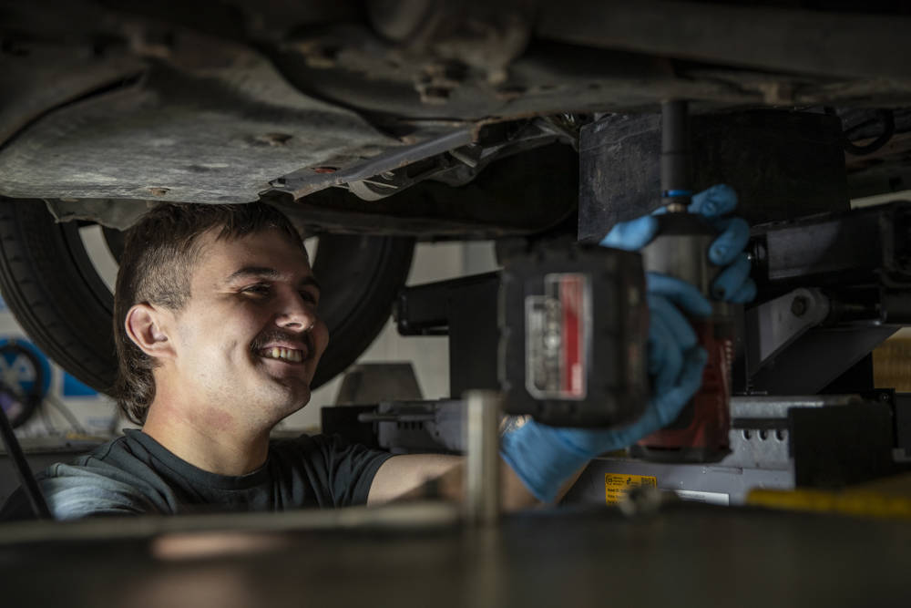 A student working underneath a car on the ramps