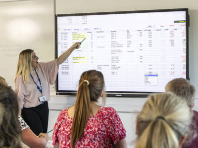 A lecturer presenting an accountancy screen to a class