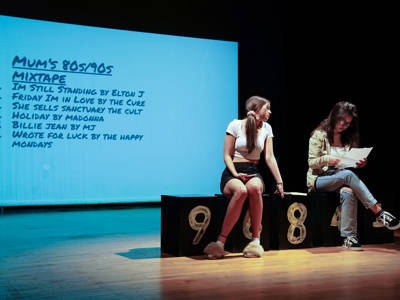 Two female students reading a script on stage 