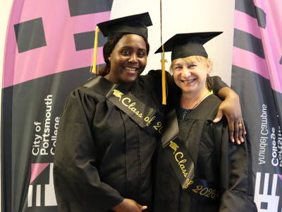 Two graduates from Level 2 ESOL arm in arm