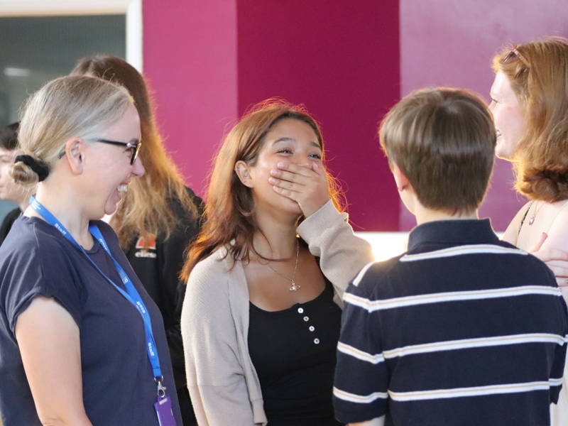 Speechless female student covers her mouth with her hand with joy after finding out her A Level results