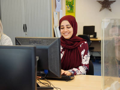 Adult learner using a desktop computer in a college IT suite.