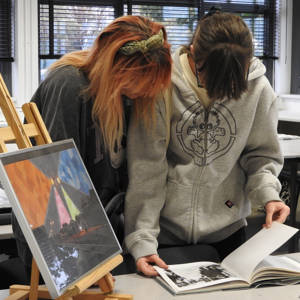 Two girls look through a picture book