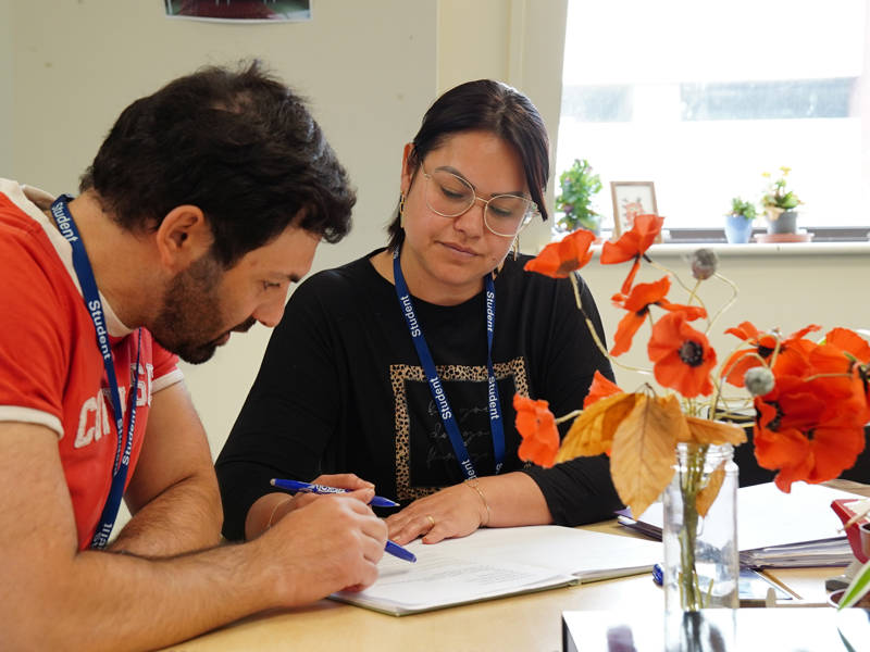 Male and female ESOL students studying in the classroom.