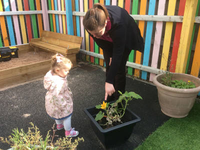 A teacher and a child in the garden at Honeypot Nursery, City of Portsmouth College 