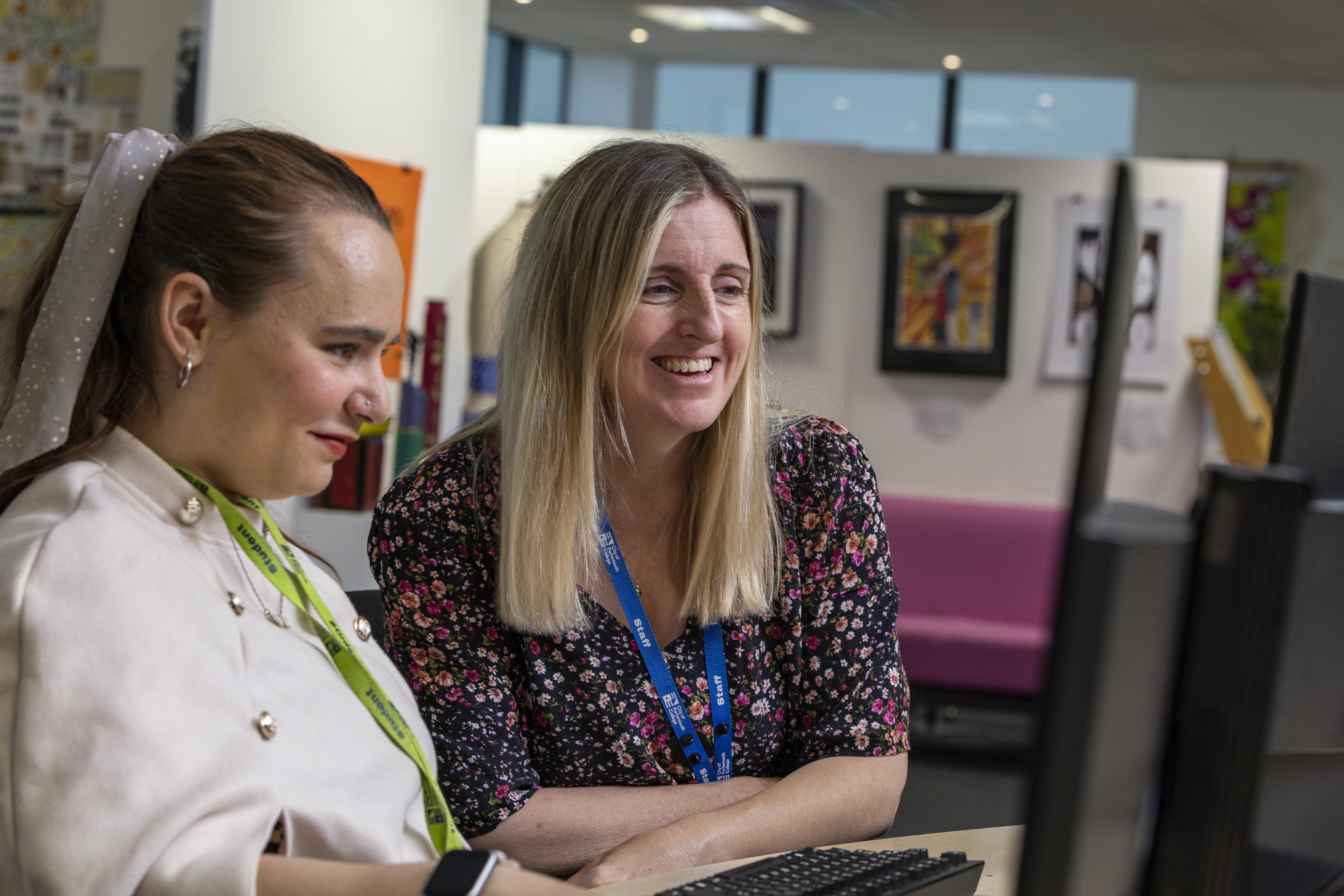A  COPC staff member helping a student on a computer 