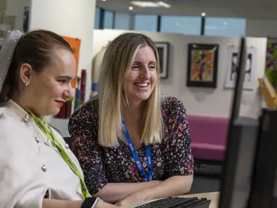 A COPC staff member helping a student on a computer