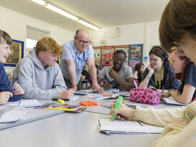 Students and their lecturer studying around a classroom table 