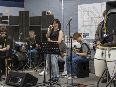 Music performance students singing and playing instruments 
