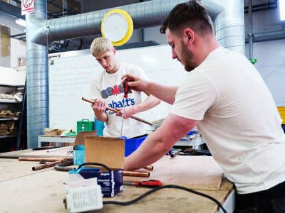 two male plumbing students working in the workshop at City of Portsmouth College 