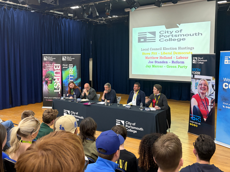 The City of Portsmouth College hustings 2026, showing four candidates and politics lecturer Steve Fitzgerald, centre, at a table in front of an audience of students