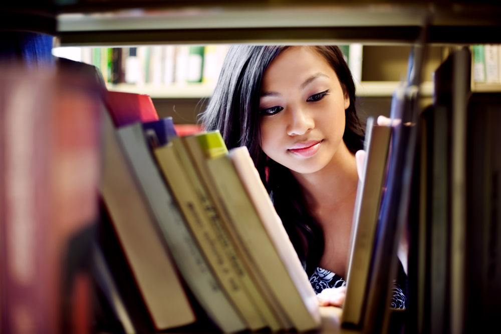 A portrait of an Asian school student in library