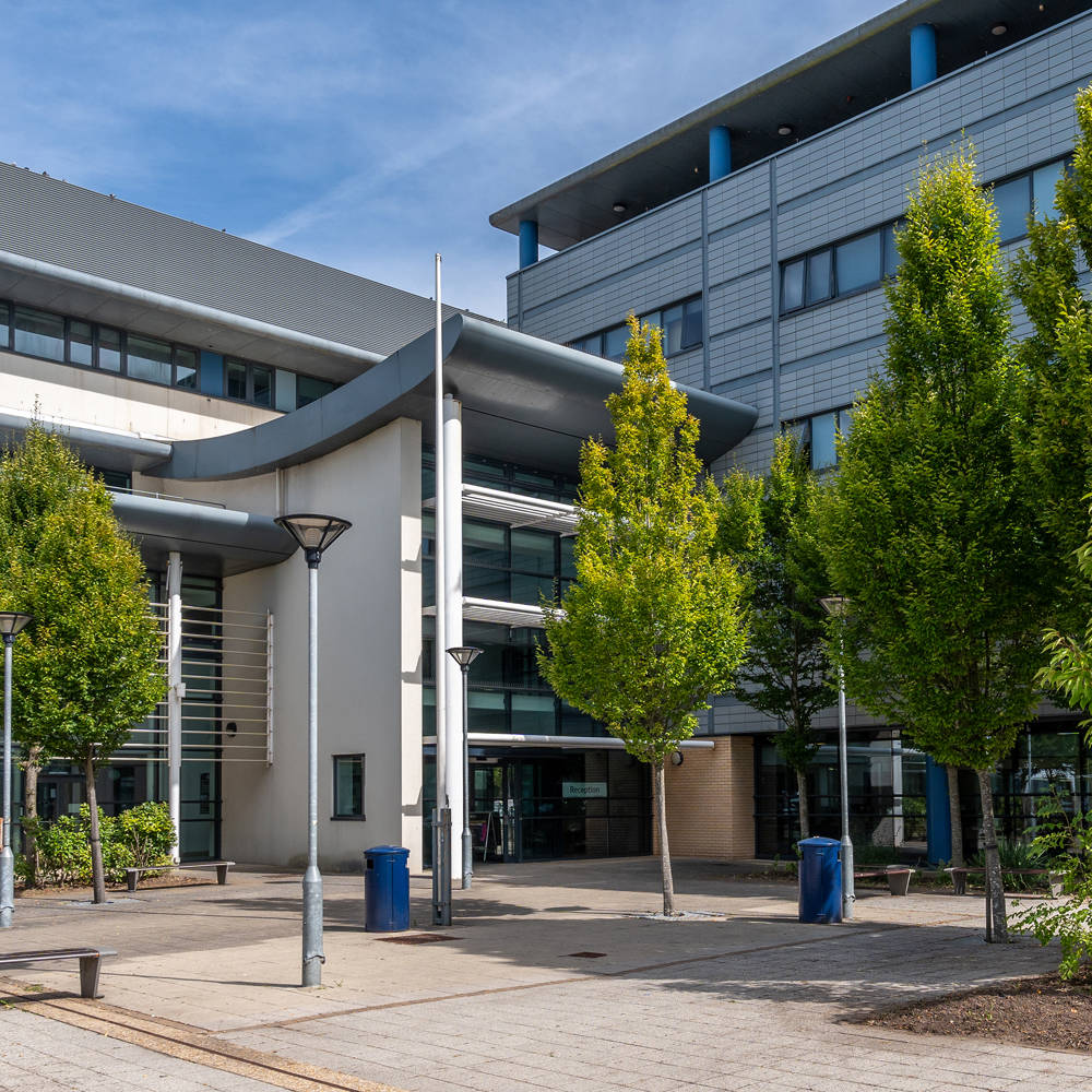Highbury Campus exterior at City of Portsmouth College with modern buildings, landscaped walkways and main entrance.