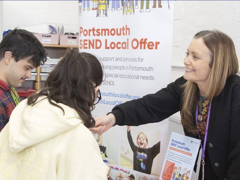 Image shows a Portsmouth City Council worker speaking to attendees of the Moving Forward event